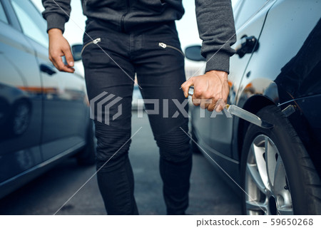 Car robber holds knife at the tire, hooligan Car robber holds knife at the tire, hooligan 59650268