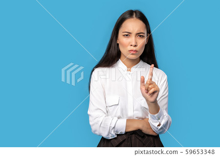 Freestyle. Young woman wearing shirt and skirt standing isolated on blue pointing up concerned 59653348
