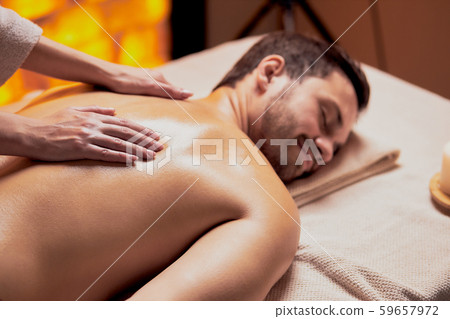 Female masseur does back massage to the young man in spa beauty salon 59657972