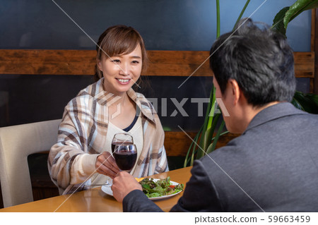 Men and women eating in a restaurant 59663459