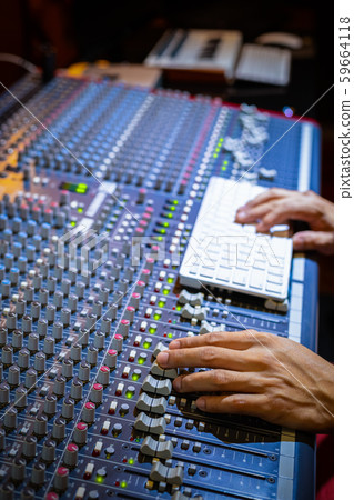 male producer, sound engineer hands working on audio mixing console in broadcasting, recording studio 59664118