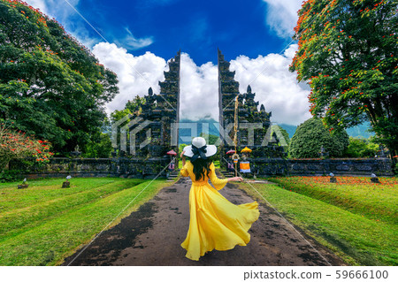 Woman walking at big entrance gate, Bali  59666100
