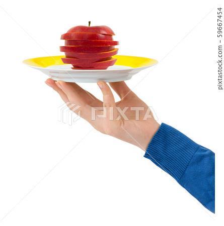Hand with plate and chopped apple 59667454