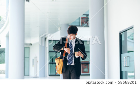 Young businessman worried looking at his wrist Young businessman worried looking at his wrist 59669201