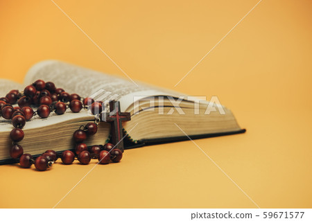 Open Holy Bible with old beads on a yellow Open Holy Bible with old beads on a yellow 59671577