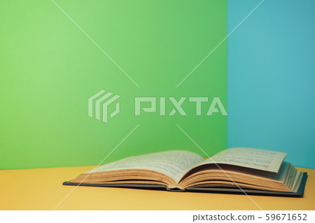 Beautiful open book on a yellow table and blue 59671652