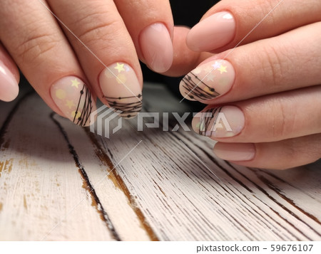 Gray striped nail design on female hand close up. 59676107