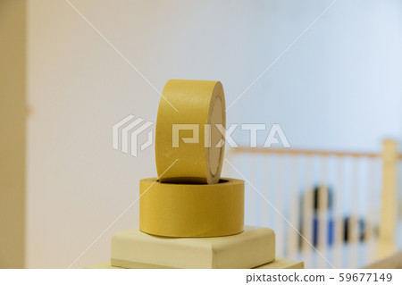 Painter protecting sills with yellow painters tape 59677149