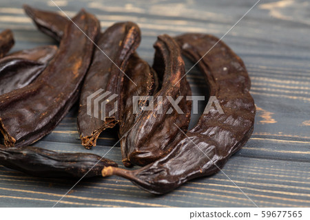 Carob. Healthy organic sweet carob pods on gray 59677565