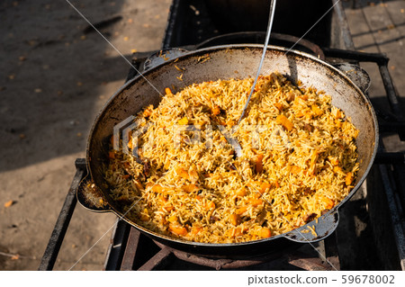 Tasty Uzbek pilaf in a cauldron on fire  59678002