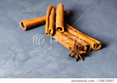 Cinnamon and cloves on grey background. Cinnamon and cloves on grey background. 59678907
