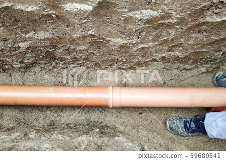 The contractor installs a sewer in a ditch and The contractor installs a sewer in a ditch and 59680541