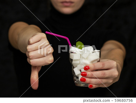 girl holds a glass filled with cubes of white sugar girl holds a glass filled with cubes of white sugar 59680756