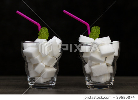glass filled with pieces of white sugar, a glass filled with pieces of white sugar, a 59680874