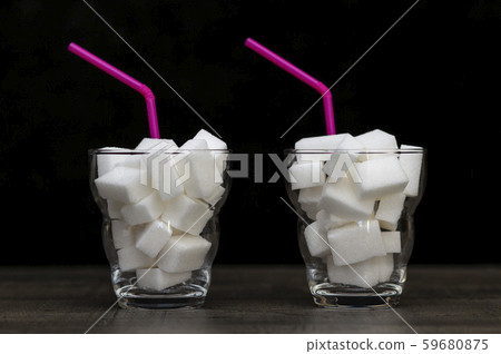 glass filled with pieces of white sugar, a glass filled with pieces of white sugar, a 59680875