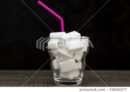 glass filled with pieces of white sugar, a glass filled with pieces of white sugar, a 59680877