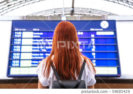 Girl looks on schedule on train station. Back view Girl looks on schedule on train station. Back view 59685429