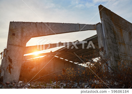 Concrete beams and walls of the destroyed old warehouse in the rays of the rising sun Concrete beams and walls of the destroyed old warehouse in the rays of the rising sun 59686184