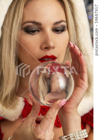 beautiful girl in a Christmas costume holds a mysterious, magic glass ball in her hands 59687917