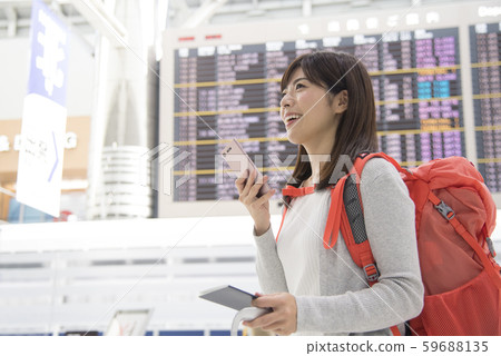 Airport lobby bulletin board woman mobile phone 59688135