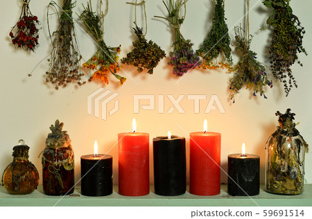 Still life with witch bottles, burning candles and dry flowers and herbs.  59691514