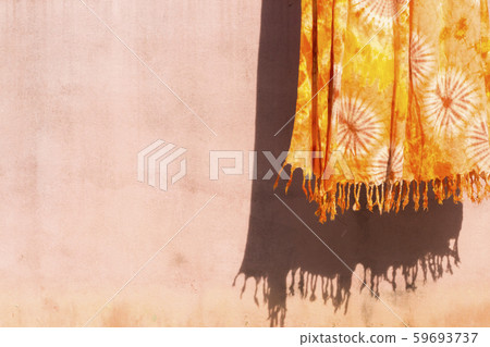 background texture orange clothes on washing line dry in the sun beside cement walls  59693737