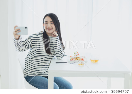 Young woman smartphone meal photo Young woman smartphone meal photo 59694707