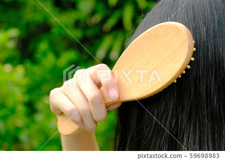 Woman brushing her long straight natural black hair 59698983
