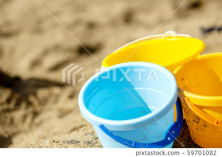 Light blue and yellow and orange buckets and copy space placed in a sandbox Light blue and yellow and orange buckets and copy space placed in a sandbox 59701082