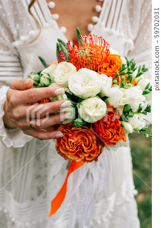 Beautiful wedding bouquet in hands of the bride Beautiful wedding bouquet in hands of the bride 59702031