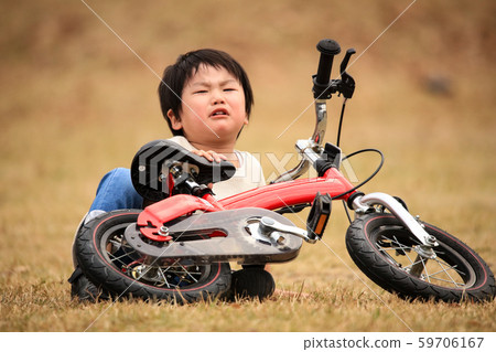 A boy who fell while practicing riding a bicycle 59706167