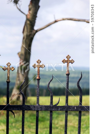 Beautiful small iron crossed fence decoration, graveyard gate with green woods, life and death  59708343