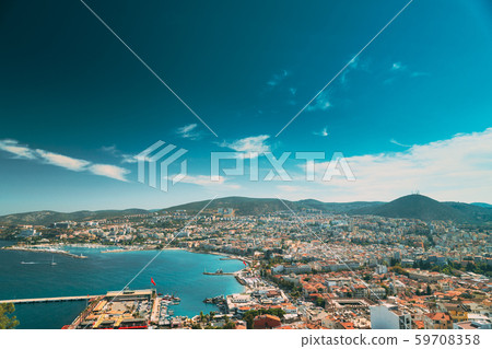 Kusadasi, Aydin Province, Turkey. Waterfront And Kusadasi Cityscape In Sunny Summer Day. Scenic View Kusadasi, Aydin Province, Turkey. Waterfront And Kusadasi Cityscape In Sunny Summer Day. Scenic View 59708358