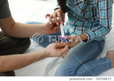 Couple with pregnancy test results Couple with pregnancy test results 59709673