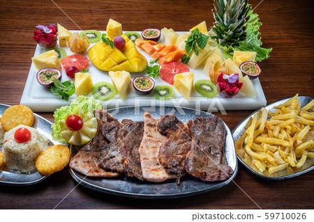 Grilled meat, side dish and dessert in a restaurant. 59710026