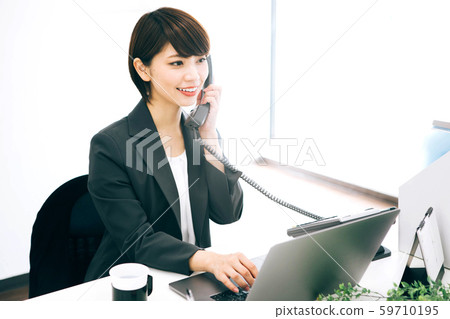 一個在辦公室處理電話的女人 59710195
