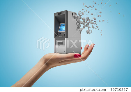 Side closeup of woman's hand facing up and holding small ATM which has started to dissolve into 59710237