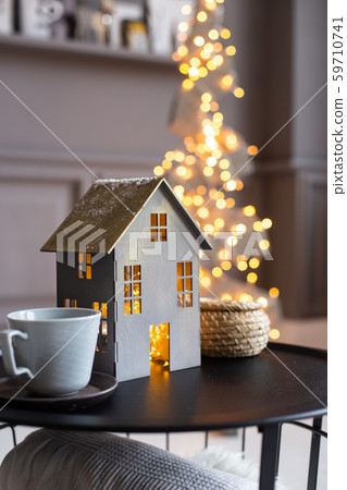 Closeup of paper house and two empty cups on a black table and a fir of wooden planks on background 59710741