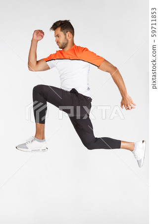 Vertical full-length shot sportsman in motion, attractive young football player, athlete jumping 59711853