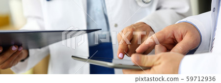 Two doctors looking in tablet pc display Two doctors looking in tablet pc display 59712936