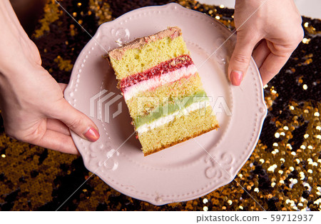 Golden brilliant tasty cake is cut into pieces. A slice of cake on a pink plate. Homemade baking for Golden brilliant tasty cake is cut into pieces. A slice of cake on a pink plate. Homemade baking for 59712937