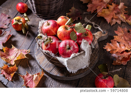 Fresh ripe apples in a basket on a rustic table 59714808