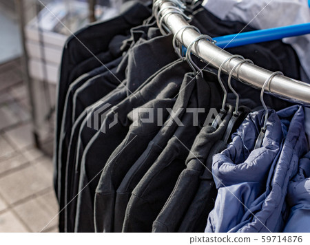 Different clothes hanging in a store. Collection modern fashion shopping jackets. Sale concept Different clothes hanging in a store. Collection modern fashion shopping jackets. Sale concept 59714876