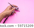 Airbrush double action spray work for hobby, makeup, art work, cake decoration, body paint in male hand pink background 59715209