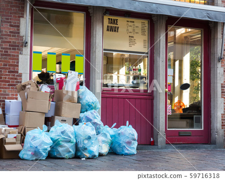 Blue garbage bags and boxes on sidewalk, Europe Blue garbage bags and boxes on sidewalk, Europe 59716318