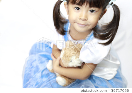 Infant (4 years old) wearing a dress and holding a stuffed animal Infant (4 years old) wearing a dress and holding a stuffed animal 59717066