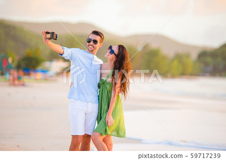 Young couple walking on tropical beach with white sand and turquoise ocean water at Antigua island 59717239