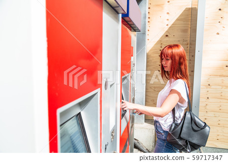 Woman touches screen of terminal to buy ticket Woman touches screen of terminal to buy ticket 59717347