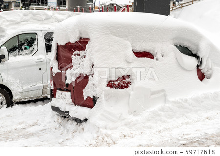 Car on a street covered with big thick snow layer after heavy snowfall. Extreme blizzard aftermath 59717618