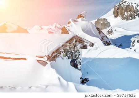 Scenic Highland alpine old abandoned stone hut with chimney snowbound by thick snow layer after Scenic Highland alpine old abandoned stone hut with chimney snowbound by thick snow layer after 59717622